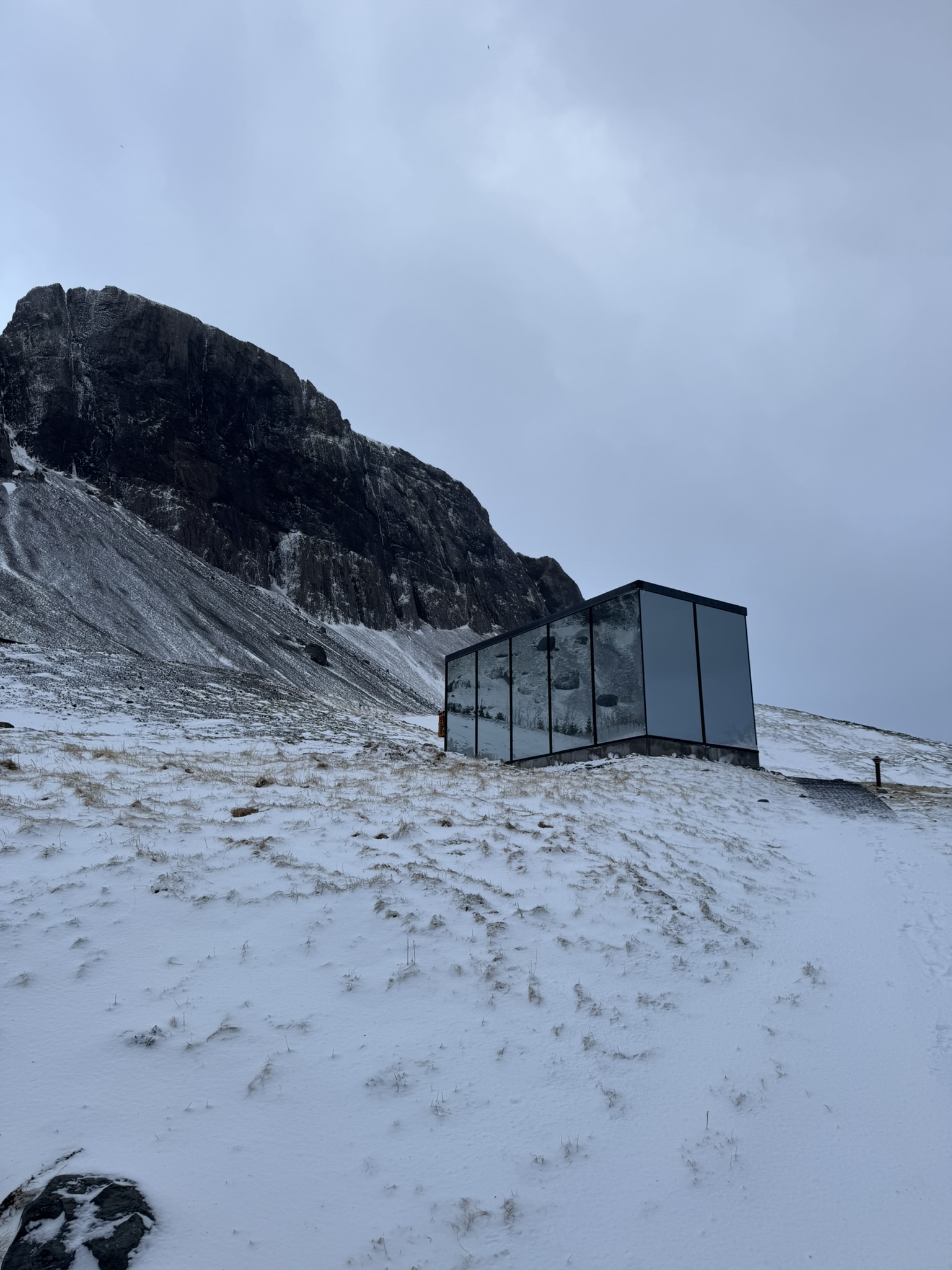 Glass cabin with a mountain view.