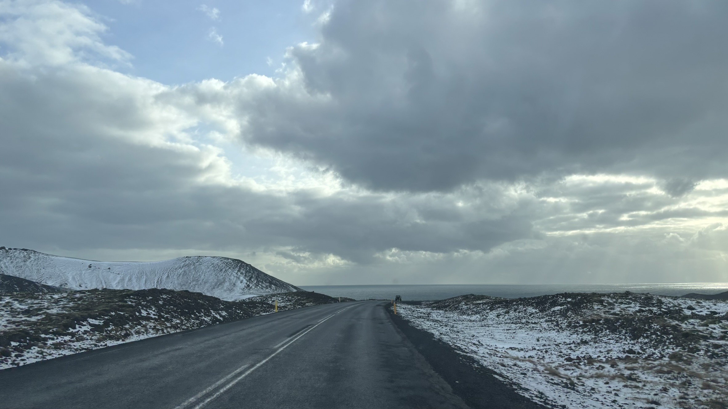 Road view with mountain and sky in the background.
